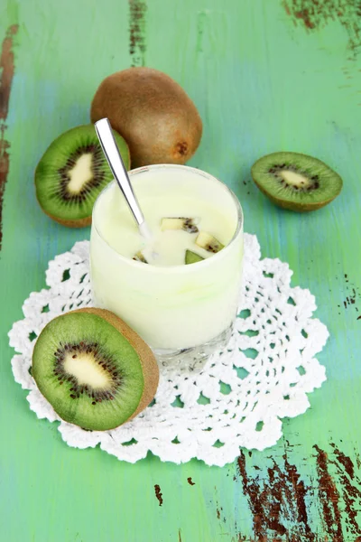 Delicious yogurt in glass with fruit on wooden table close-up — Stock Photo, Image