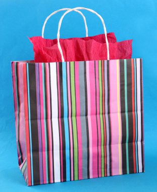 mavi arka plan üzerinde çizgili alışveriş çantası