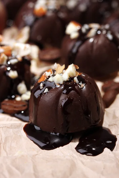 Dulces de chocolate y granos de café, sobre papel beige — Foto de Stock