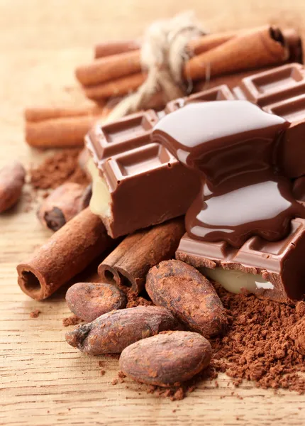 Склад шоколадних цукерок, какао та спецій на дерев'яному фоні — стокове фото