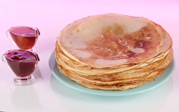 Pannkakor på plattan på rosa bakgrund — Stockfoto