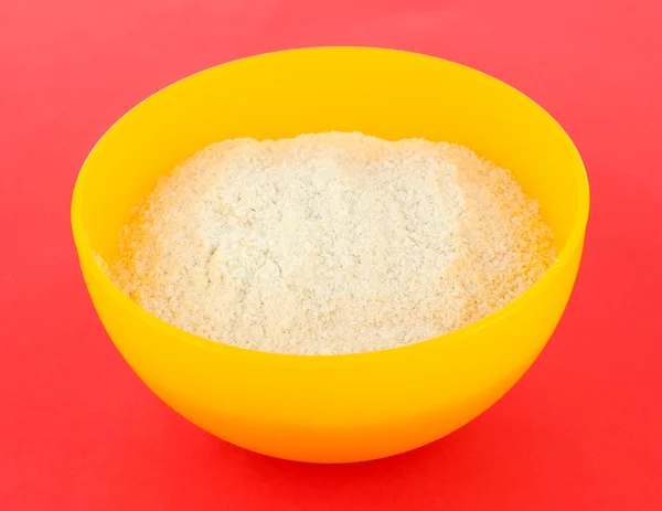 Powdered milk in bowl for baby on red background — Stock Photo, Image