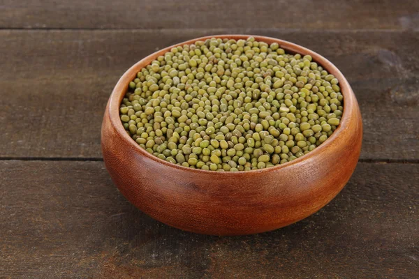 Haricots dans un bol sur fond en bois — Photo