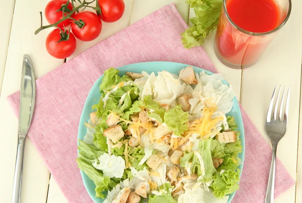 Cézár saláta, kék tányéron a színes fából készült háttér — Stock Fotó