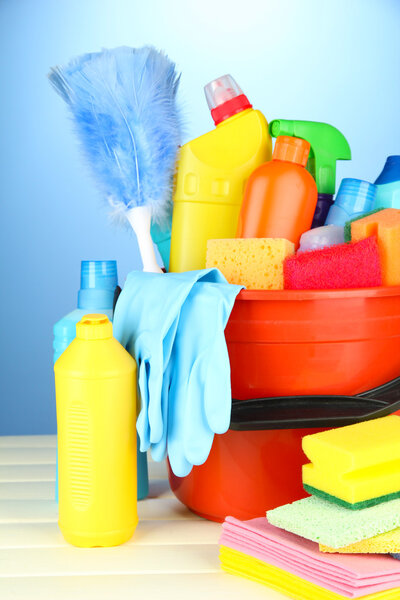 Cleaning items in bucket on color background