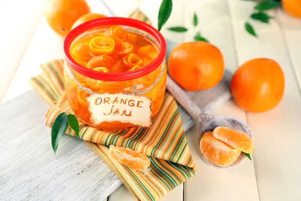 Engarrafamento de laranja com raspas e tangerinas, sobre mesa de madeira branca — Fotografia de Stock