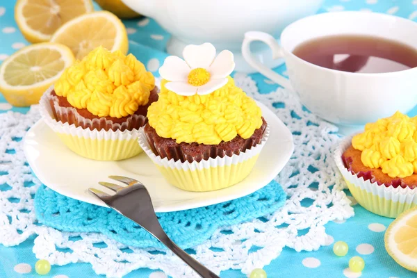 Beautiful lemon cupcakes and flavored tea on dining table close-up — Stock Photo, Image