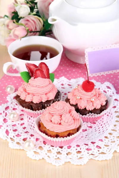 Beautiful strawberry cupcakes and flavored tea on dining table close-up — Stock Photo, Image