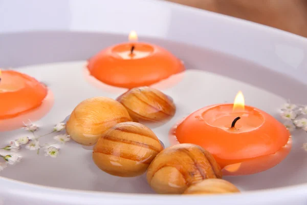 Hermosas velas nadan en un hermoso plato en la mesa de madera de cerca — Foto de Stock