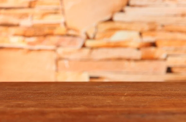 Mesa de madeira em tijolos fundo — Fotografia de Stock