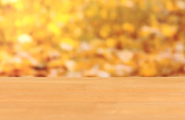 Wooden table on bright yellow background — Stock Photo, Image