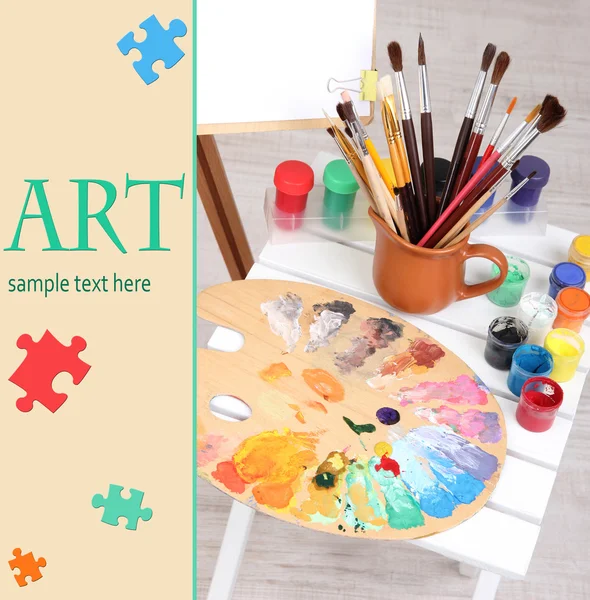 Wooden easel with clean paper and art supplies in room — Stock Photo, Image