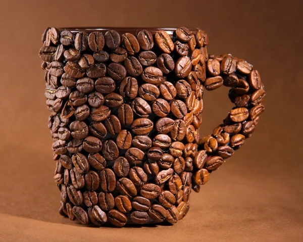 Xícara de grãos de café, em fundo marrom — Fotografia de Stock