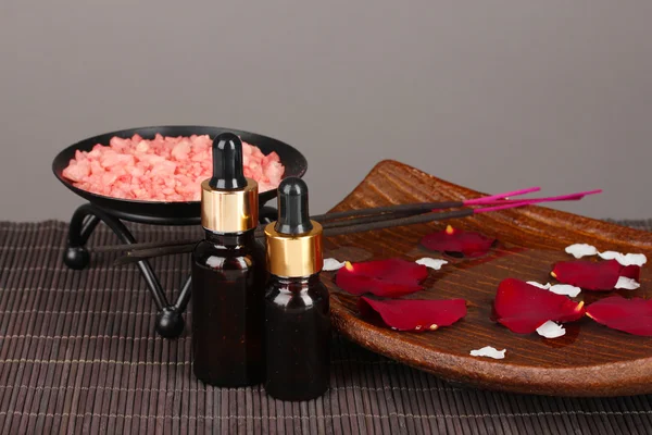 Composição de spa com óleos de aroma na mesa em fundo cinza — Fotografia de Stock