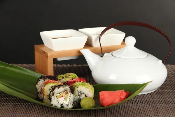 Tasty Maki sushi - Roll on green leaf on table on gray background — Stock Photo, Image