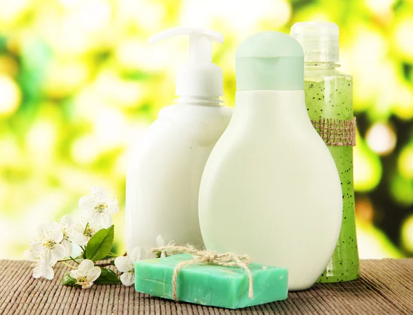 Cosmetics bottles and natural handmade soap on green background — Stock Photo, Image