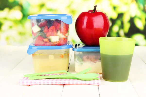 Smakelijke lunch in plastic verpakkingen, op houten tafel op lichte achtergrond — Stockfoto