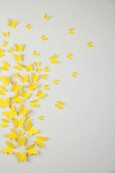 Papiergelbe Schmetterlinge fliegen an der Wand in verschiedene Richtungen — Stockfoto