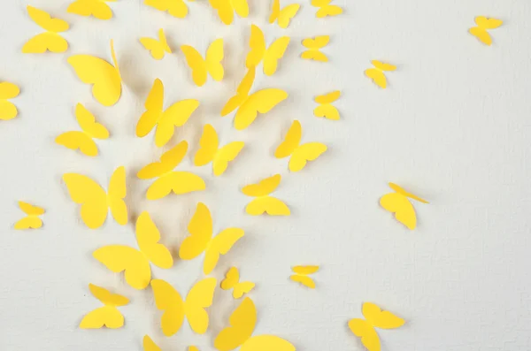 Бумажные желтые бабочки летают на стене в разных направлениях — стоковое фото