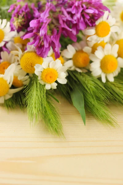 Wild flowers and green spikelets, on wooden background — Stock Photo, Image