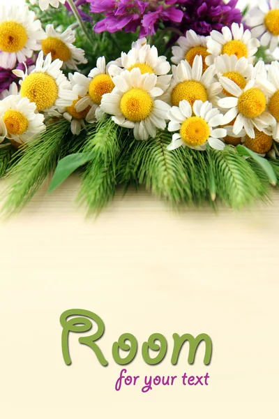 Divoké květiny a zelené klásky na dřevěný stůl s copy prostor — Stock fotografie