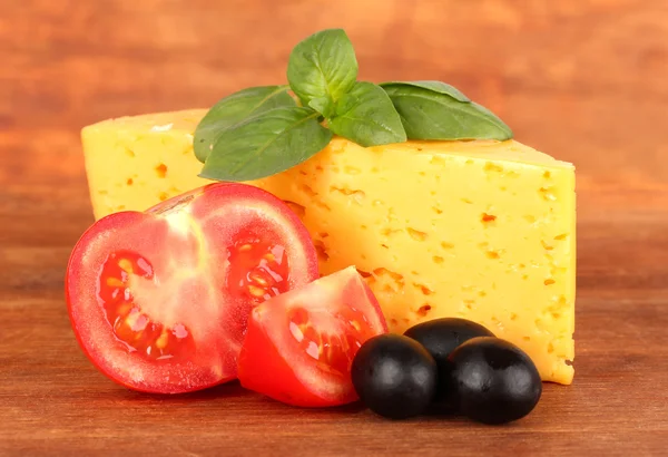 Formaggio, basilico e verdure su fondo di legno — Foto Stock