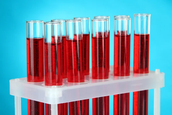 Test tubes with blood in laboratory on blue background Stock Picture