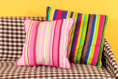 kanepede sarı arka plan üzerinde renkli yastıklar