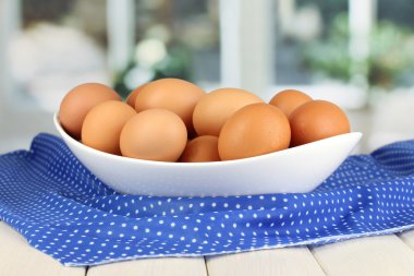 ahşap masa penceresinin arka plan üzerinde beyaz kase yumurta