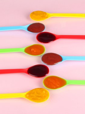Bebek püresi pembe bir arka plan üzerine kaşık içinde
