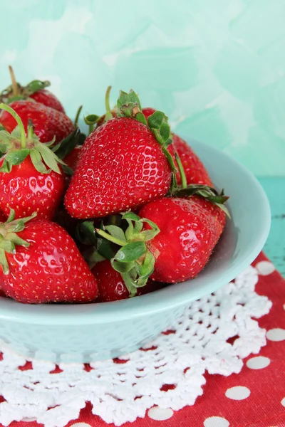 Erdbeeren im Teller auf Serviette auf blauem Hintergrund — Stockfoto