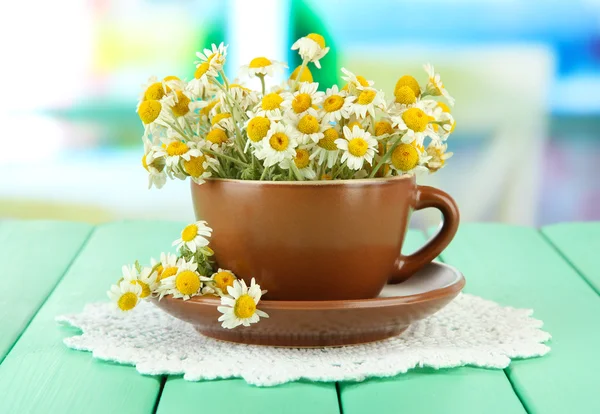 Bouquet di fiori di camomilla in tazza, su sfondo luminoso — Foto Stock