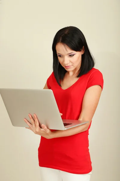 Mooie jonge vrouw met laptop in de kamer — Stockfoto