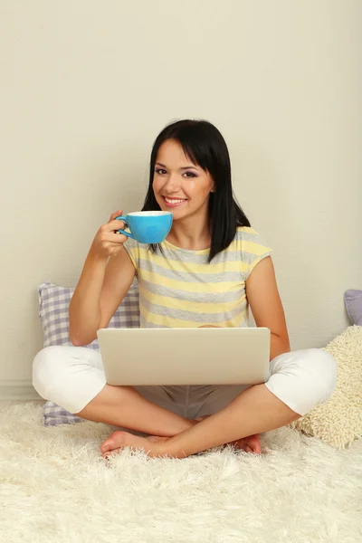 Beautiful young woman sitting with notebook in room — Stock Photo, Image