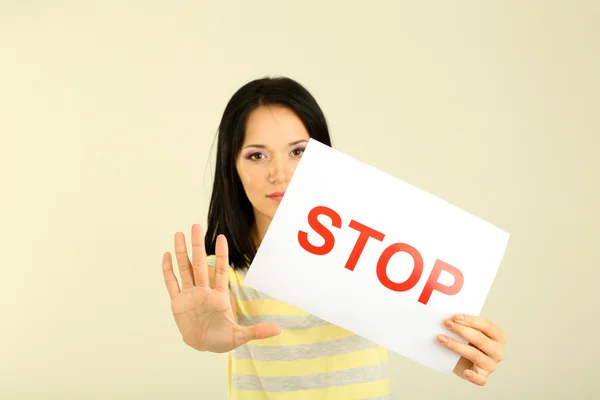 Mädchen zeigt Stoppschild auf grauem Hintergrund — Stockfoto