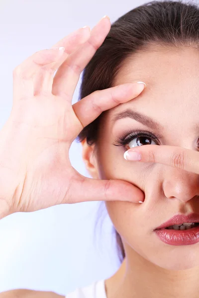 Mladá žena uvedení kontaktní čočky v oku zblízka — Stock fotografie