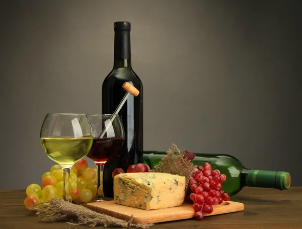 Komposition mit Wein, Blauschimmelkäse und Trauben auf Holztisch, auf grauem Hintergrund — Stockfoto