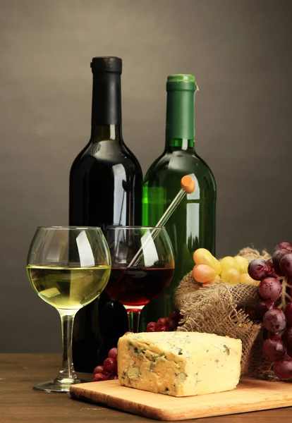 Composición con vino, queso azul y uva sobre mesa de madera, sobre fondo gris — Foto de Stock