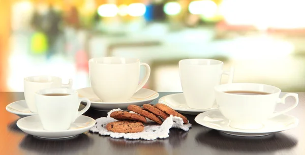 Tazas de café y galletas en servilleta en la mesa oscura en el fondo de la habitación — Foto de Stock