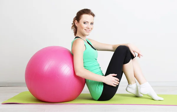 Porträtt av vacker ung kvinna övningar med gym boll — Stockfoto