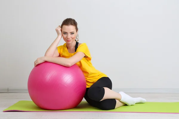 Porträtt av vacker ung kvinna övningar med gym boll — Stockfoto