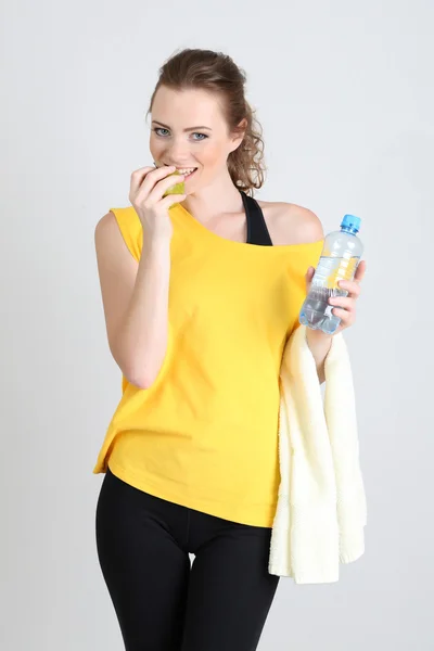 Krásná mladá žena s lahví vody a apple — Stock fotografie