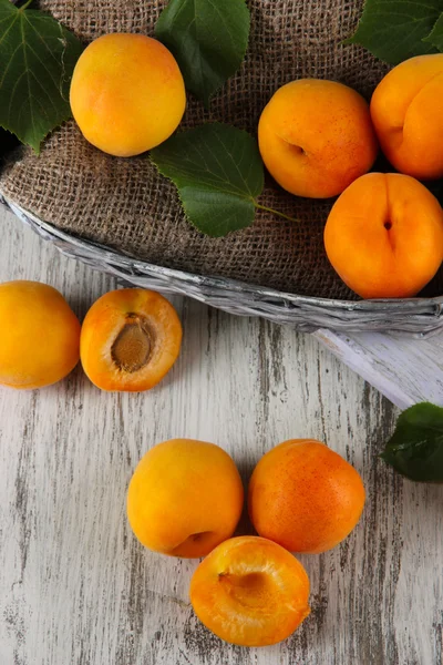 Apricots in basket on wooden table — Stock Photo, Image