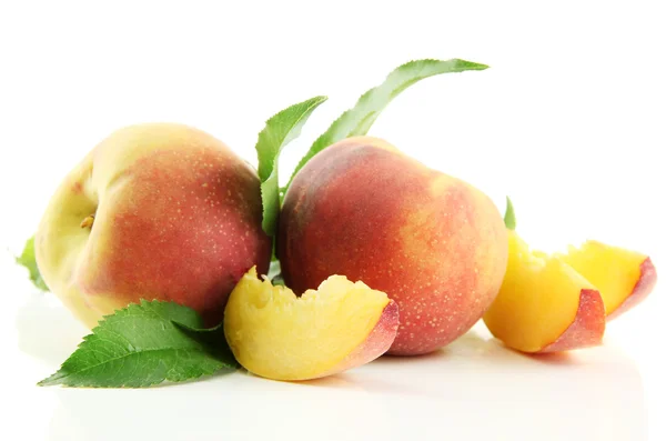 Rijpe zoete perziken met bladeren, geïsoleerd op wit — Stockfoto