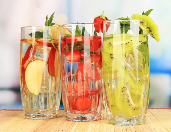 Copos de bebidas de frutas com cubos de gelo na mesa no café — Fotografia de Stock