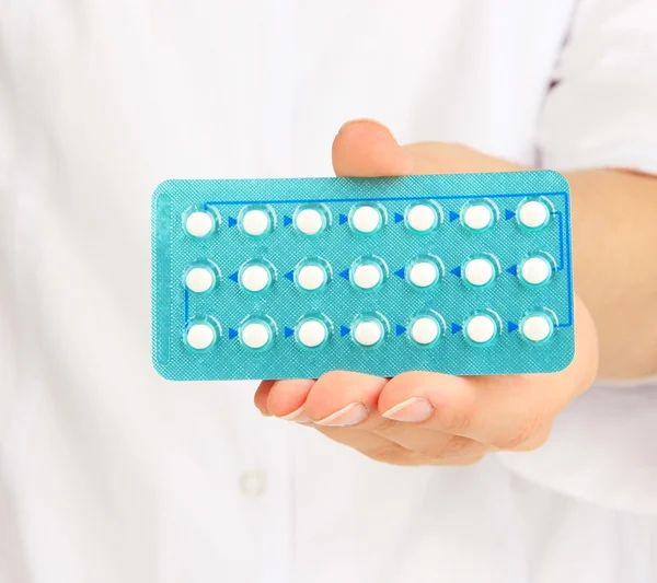 Las píldoras hormonales en la mano del médico aislado en blanco —  Fotos de Stock