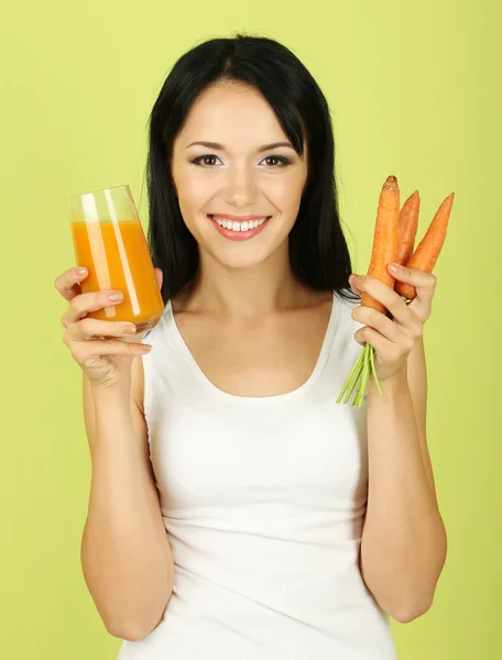 Girl with fresh carrot and juice on green background — Stock Photo, Image