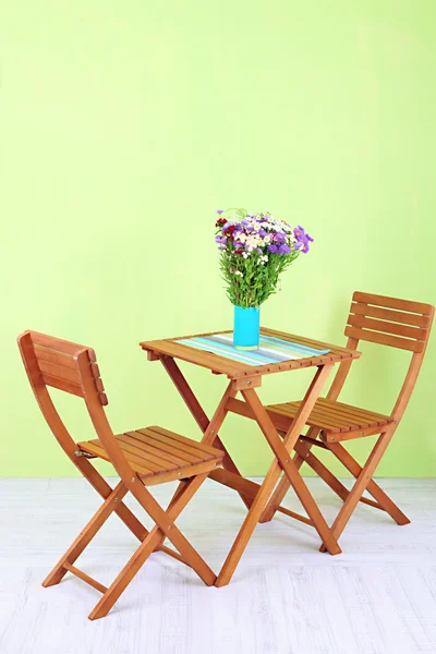 Mesa de madeira com flor no quarto — Fotografia de Stock