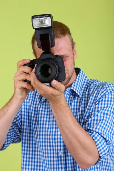 Przystojnego fotografa z aparatu, na zielonym tle — Zdjęcie stockowe