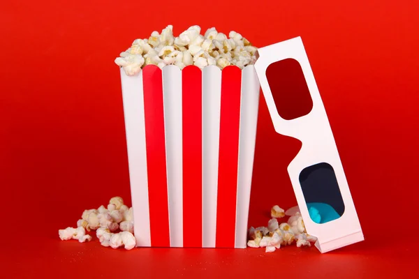 Popcorn en 3d bril op rode achtergrond — Stockfoto